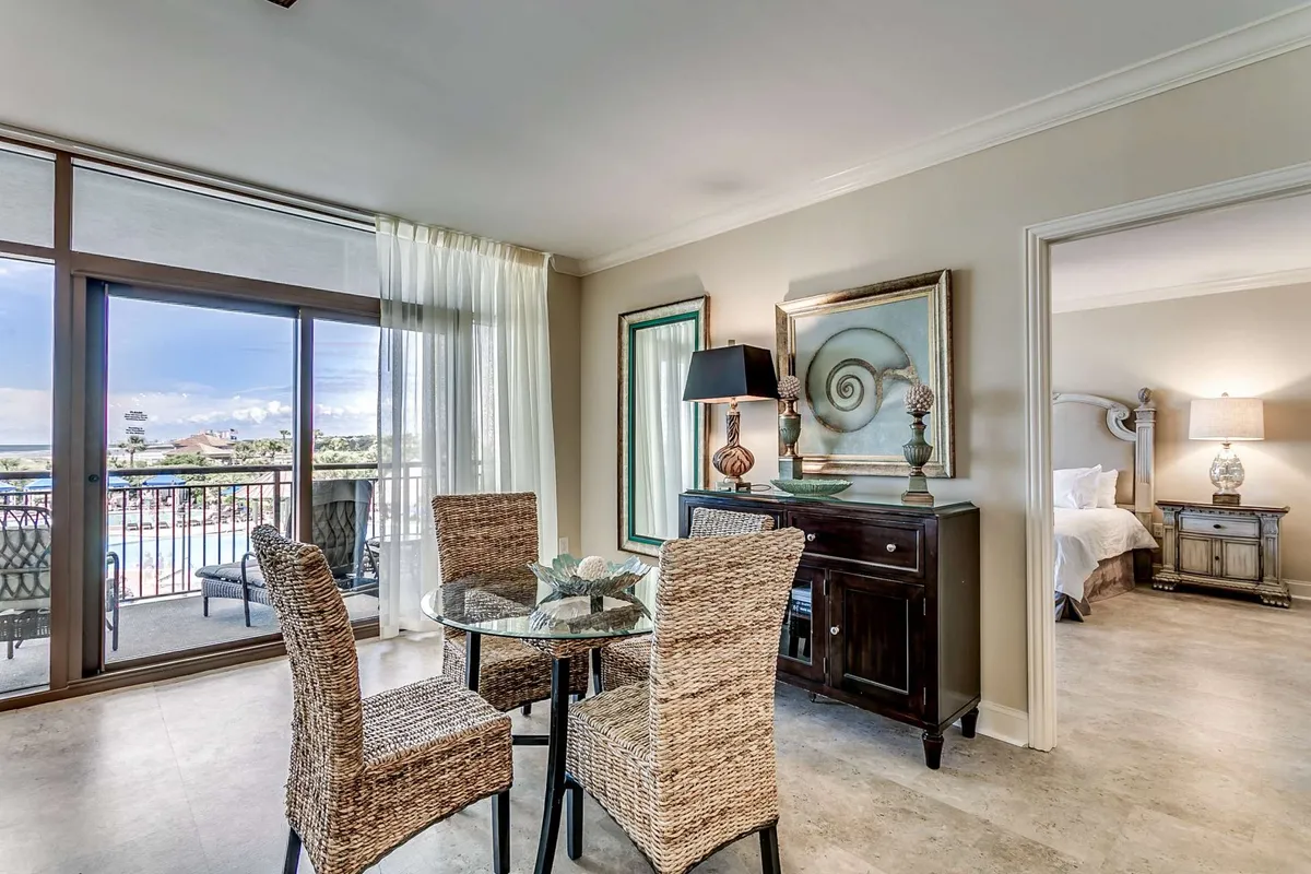 A bright dining area featuring a stylish dining table with chairs, large window draped in sheer curtains, and tasteful wall art. Natural light pours in, creating an inviting ambiance for memorable meals and lively conversation.